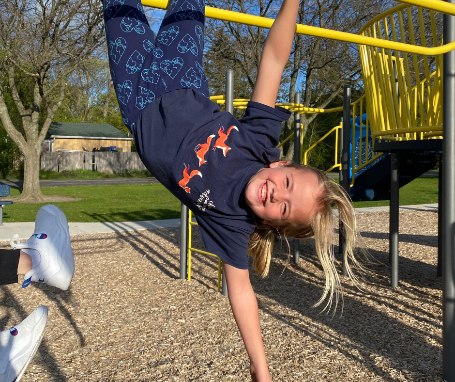 Kids Klub participant playing on swing set 